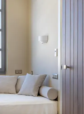a bedroom with a bed with white sheets and a door at AZADE Chania in Chania Town
