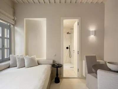 a white bedroom with a white bed and a bathroom at AZADE Chania in Chania Town