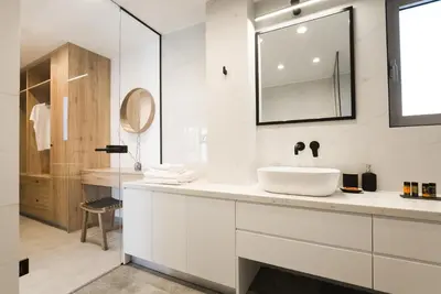 a white bathroom with a sink and a mirror at Hermes&Dione in Argoulidhés