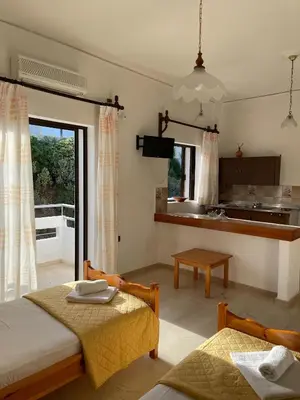 a living room with two beds and a kitchen at Aeolos Apartments Kolymbari in Kolymvari