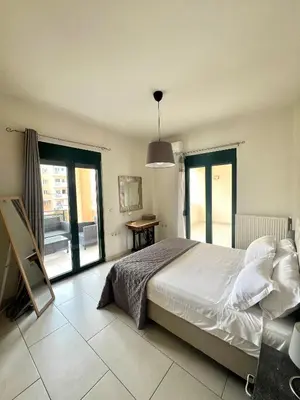 a bedroom with a bed and a large window at Zoi’s Apartment in Chania Town