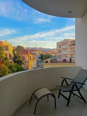 a balcony with two chairs and a view of a city at Zoi’s Apartment in Chania Town