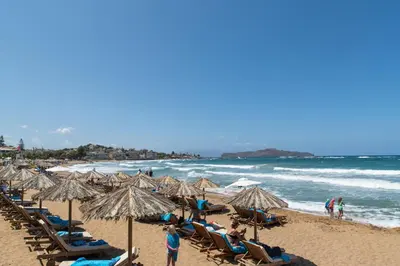 a beach with many chairs and umbrellas and the ocean at ''Meraviglia casa'' Irida apartment in Chania Town