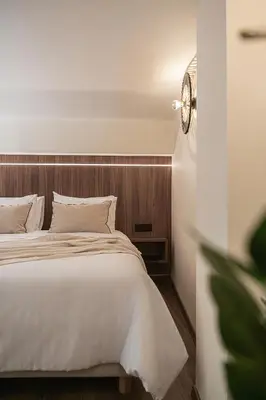 a bedroom with a white bed with a wooden headboard at Copal Experience The Port in Chania Town
