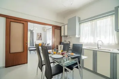 a kitchen and dining room with a glass table and chairs at The Nest of Urban Living by 8essentially in Chania Town