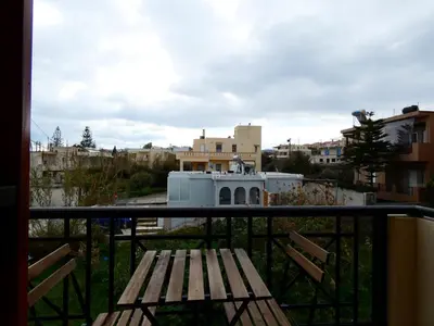 a balcony with a wooden bench and buildings at Mel Studio 1 (kalamaki) in Kalamaki Chanion