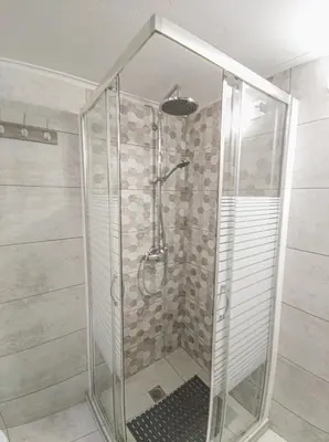 a shower with a glass door in a bathroom at Fully renovated apartment close to the bus station and the city center! in Chania Town