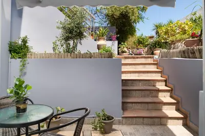 a patio with a table and chairs and stairs at ''Meraviglia casa'' Ariadne in Kato Daratso