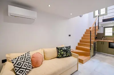 a living room with a couch and a staircase at Nem Home, amazing 1 bedroom house in Chania Town