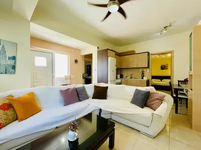 a living room with a white couch and a ceiling fan at Mersini Apartment in Chania Town