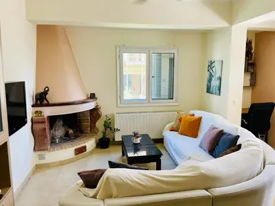 a living room with a white couch and a fireplace at Mersini Apartment in Chania Town
