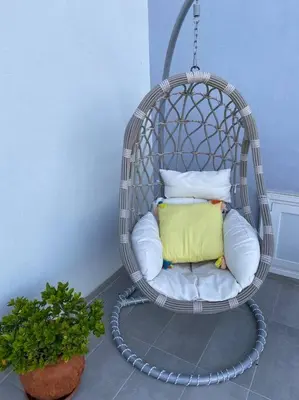 a wicker chair with pillows in a room at Villa Panorama Modi, with pool and stunning views in Chania Town