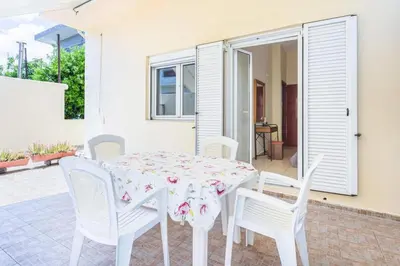 a white table with white chairs and a table with a table cloth at Neva's House in Chania in Chania Town
