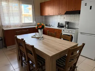 a kitchen with a wooden table with a vase of flowers on it at Neva's House in Chania in Chania Town