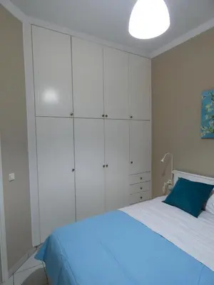 a bedroom with a bed with white cabinets and a blue pillow at Mel Studio 2 (kalamaki) in Kalamaki Chanion