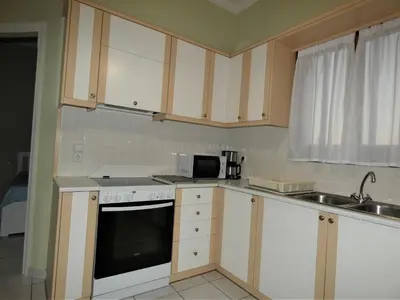 a kitchen with white cabinets and a sink and a microwave at Mel Studio 2 (kalamaki) in Kalamaki Chanion