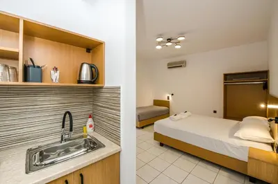 a room with a bed and a kitchen with a sink at SMAROULA in Elafonisi