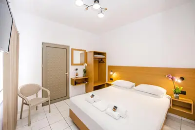 a hotel room with a bed and a chair at SMAROULA in Elafonisi