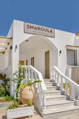 a white building with stairs and a sign on it at SMAROULA in Elafonisi