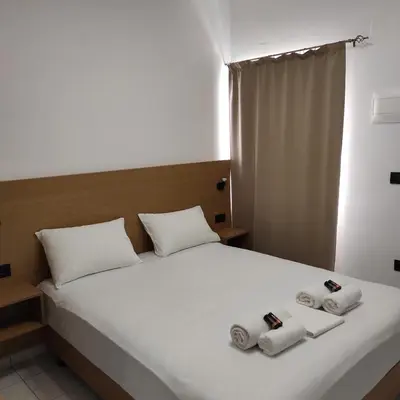a bedroom with a white bed with towels on it at SMAROULA in Elafonisi