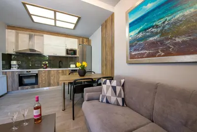 a living room with a couch and a kitchen at Rena's luxury apartment with free private parking in Chania Town