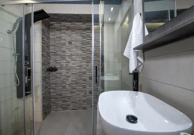 a bathroom with a white sink and a shower at Rena's luxury apartment with free private parking in Chania Town