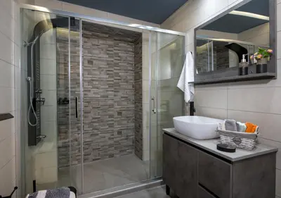 a bathroom with a glass shower and a sink at Rena's luxury apartment with free private parking in Chania Town