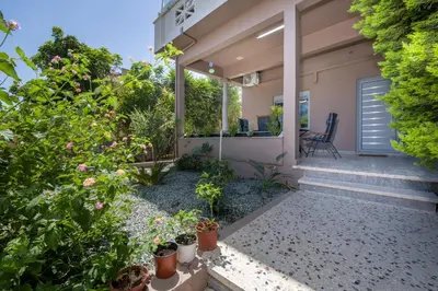 a backyard with plants and a house at Rena's luxury apartment with free private parking in Chania Town
