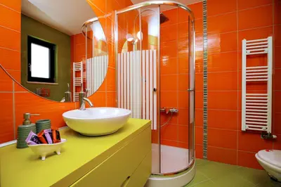 an orange bathroom with a sink and a shower at Fotini 's apartment near the city center. in Chania Town