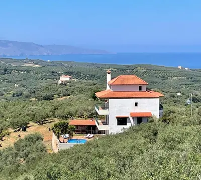 a building with an orange roof on top of a hill at Olive Villa Plataniás in Xirokámbion