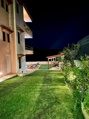 a yard of a house at night with a patio at Olive Villa Plataniás in Xirokámbion