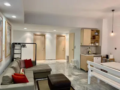 a living room with a couch and a kitchen at Aggelos and Thisbe Chania City Apartment in Chania Town