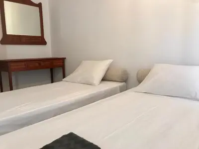 two beds in a small room with a mirror at Aggelos and Thisbe Chania City Apartment in Chania Town
