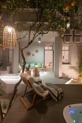 a living room with a chair and a tree at Casa Blue Dove in Chania Town