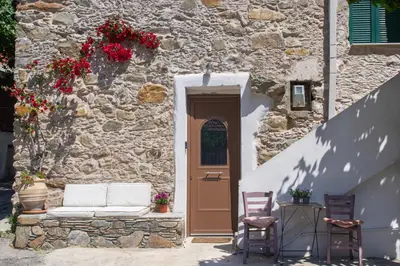 a door to a stone building with a couch and two chairs at Feneri 3 -Cozy rustic Apt 20' from Elafonisi beach in Elafonisi