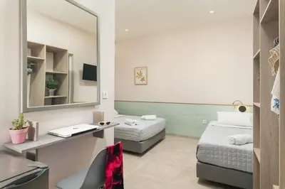 a small room with two beds and a mirror at Stefanie Studios in Agia Marina Nea Kydonias