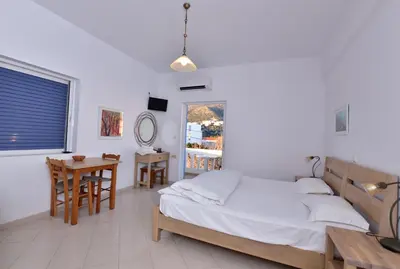 a bedroom with a bed and a table and a desk at PALEOCHORA FINIKAS Apartments in Palaiochóra
