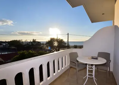 a balcony with a table and a view of the ocean at PALEOCHORA FINIKAS Apartments in Palaiochóra
