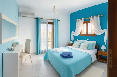 a blue bedroom with a bed and a desk at Garden House in Khóra Sfakíon