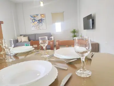 a table with plates and wine glasses on it at Sea Side View Home steps from the beach & city in Chania Town