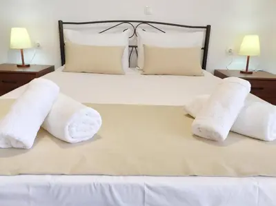 a bedroom with a bed with white towels on it at Sea Side View Home steps from the beach & city in Chania Town