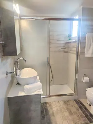 a bathroom with a shower and a sink and a toilet at Sea Side View Home steps from the beach & city in Chania Town