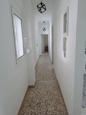 a hallway with white walls and a window and a tile floor at Oksana House in Chania Town