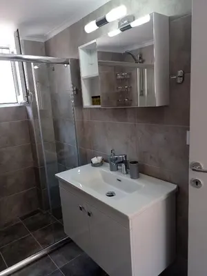 a bathroom with a white sink and a shower at Oksana House in Chania Town