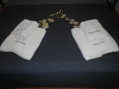 two towels and flowers on top of a bed at Domus Nicola in Chania Town
