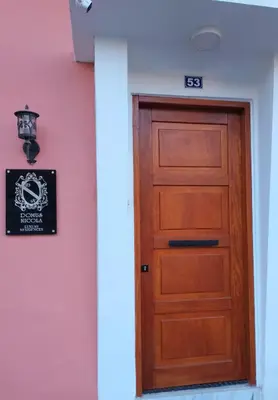 a wooden door in front of a pink wall at Domus Nicola in Chania Town