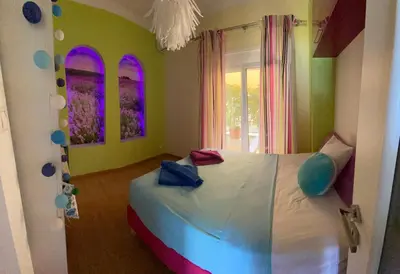a bedroom with a bed in a room with colorful walls at At the Beach! +10min= port&center. in Chania Town