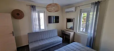 a living room with a blue couch and two windows at Fifi's luxury apartment in Plataniás