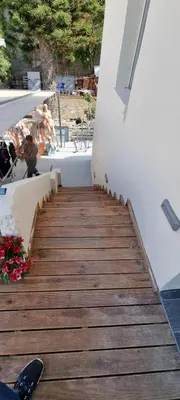 a wooden staircase leading up to a building at Fifi's luxury apartment in Plataniás
