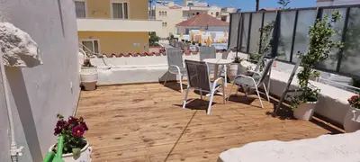 a patio with a table and chairs on a balcony at Fifi's luxury apartment in Plataniás